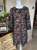 Black lace dress on a mannequin in a room with decor elements.