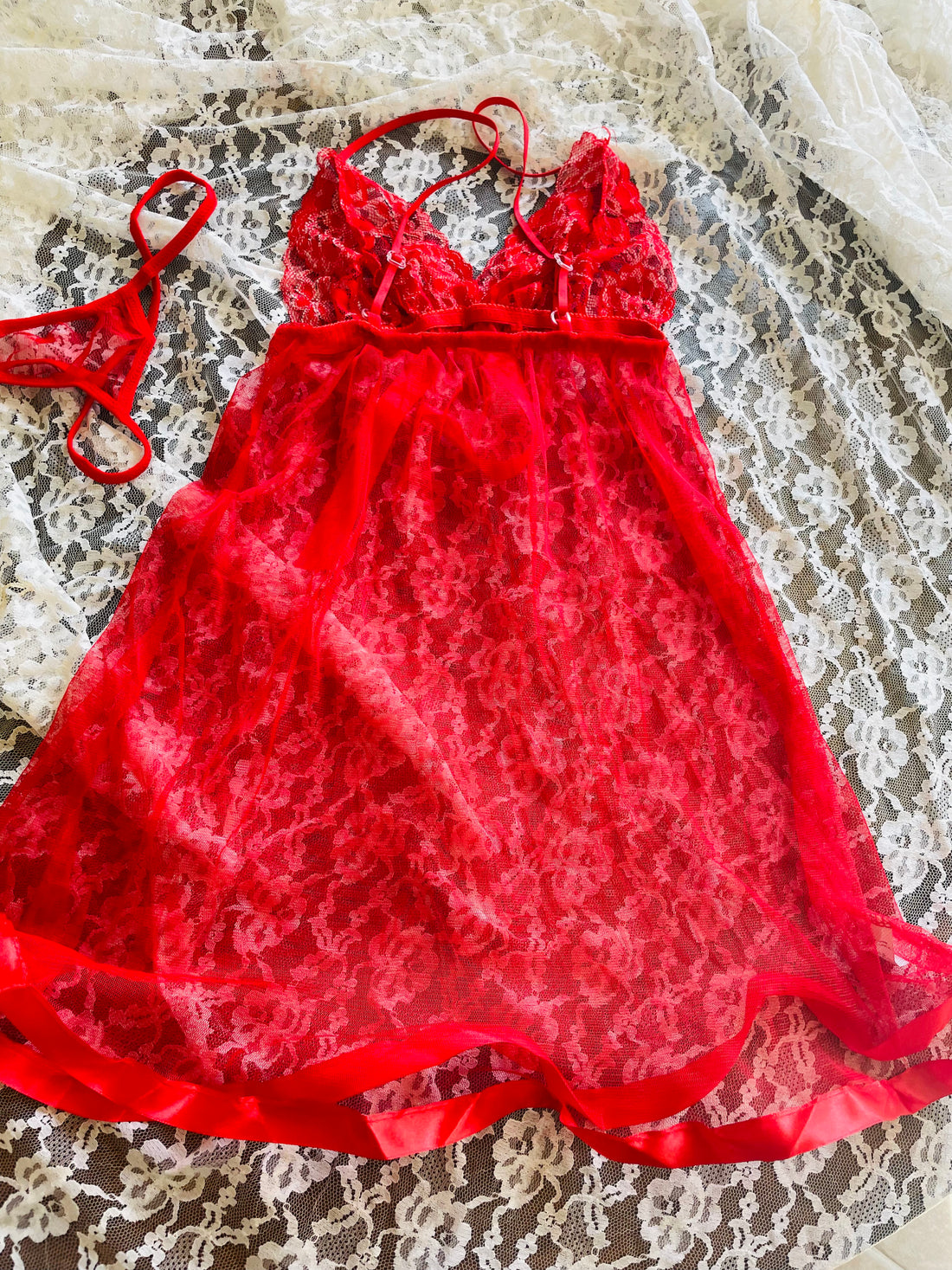 Red lace dress on a hanger in front of a mirror
