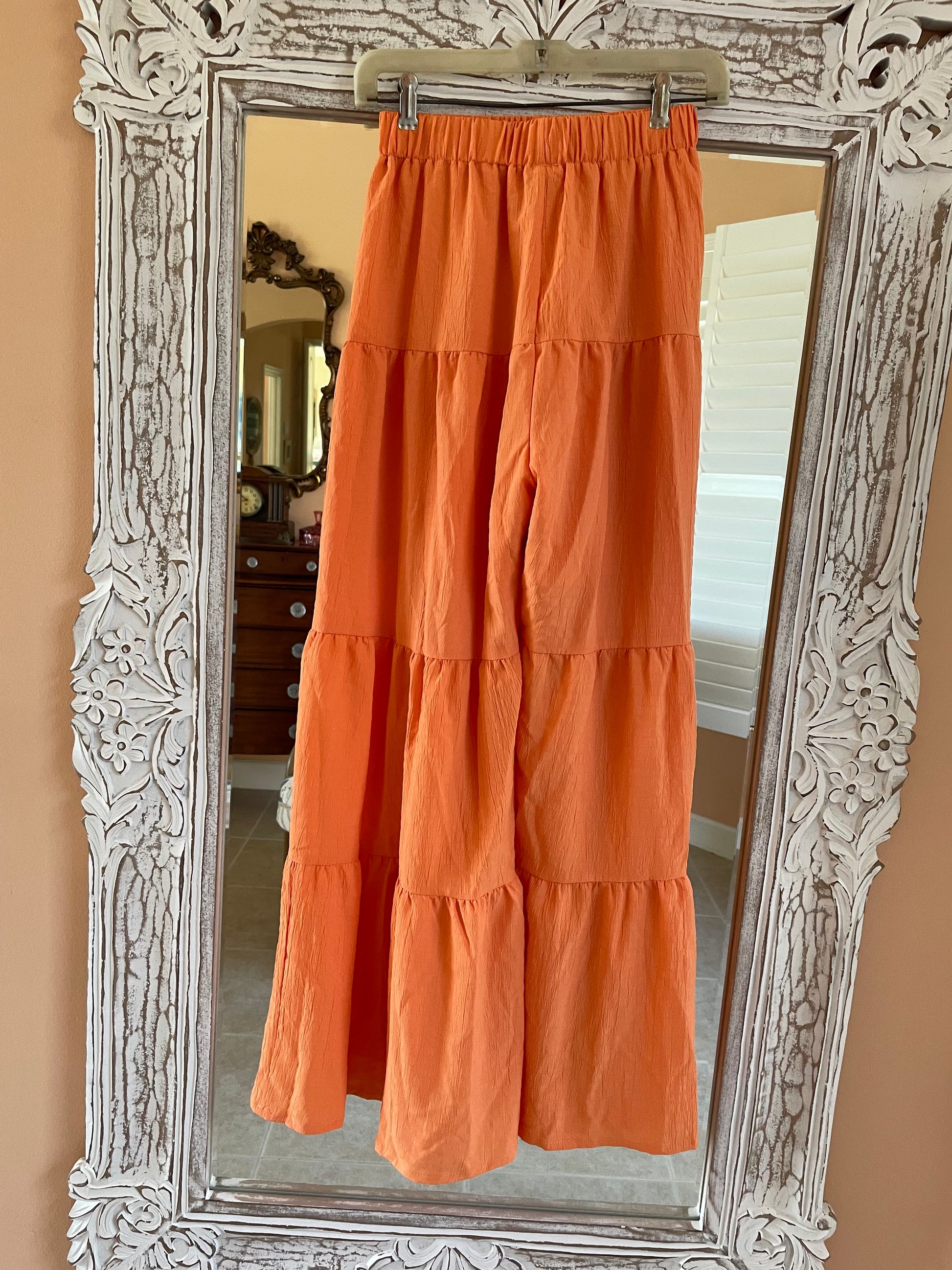 Orange fabric draped over a decorative silver mirror
