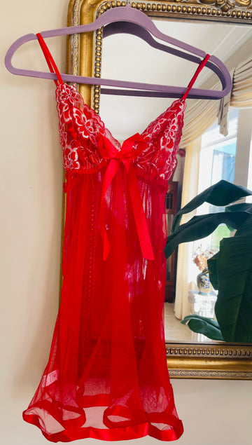 Red lace dress on a hanger in front of a mirror