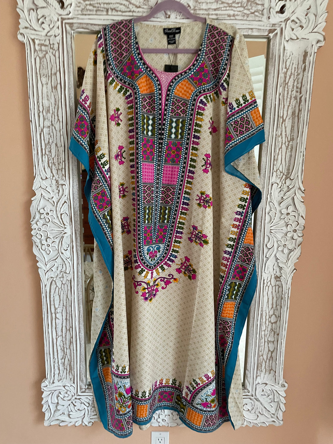 : Woman wearing colorful ornate one size boho maxi caftan by tropical lake